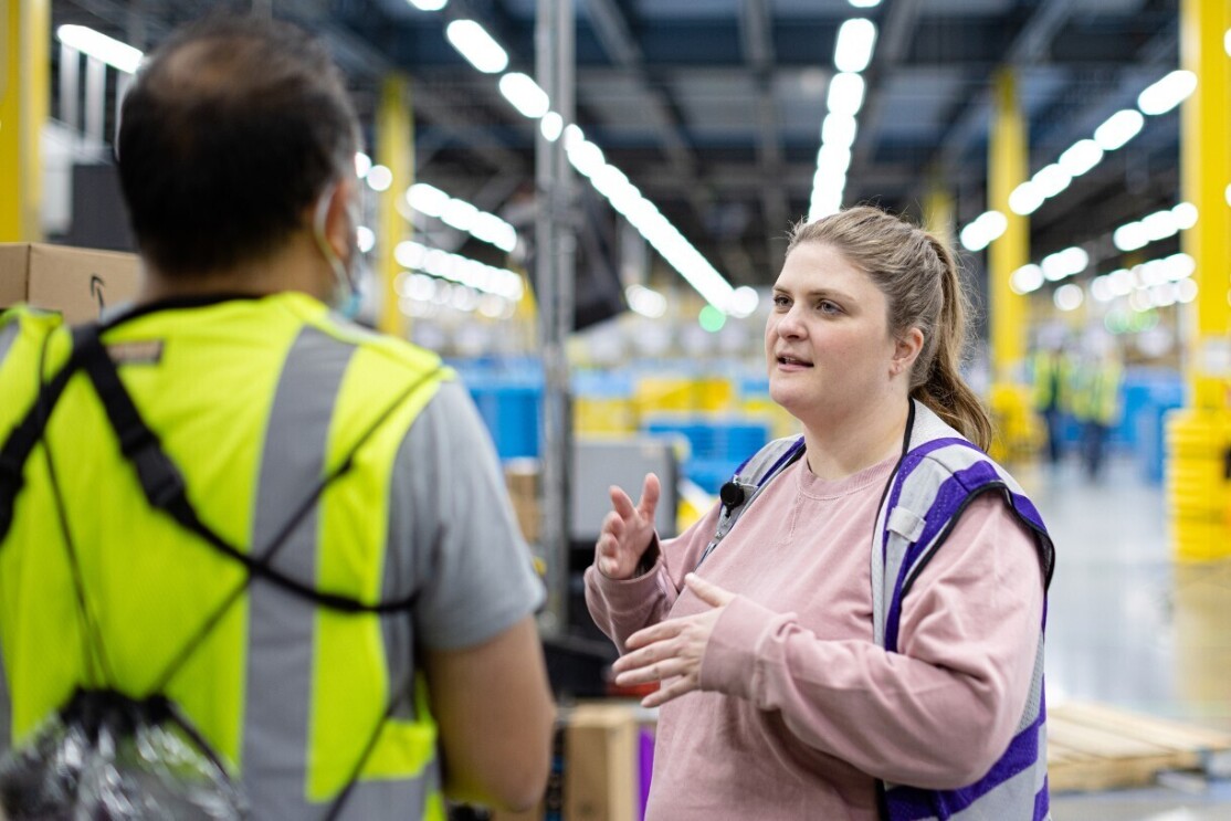 Elizabeth talks to an employee at an Amazon fulfillment center.