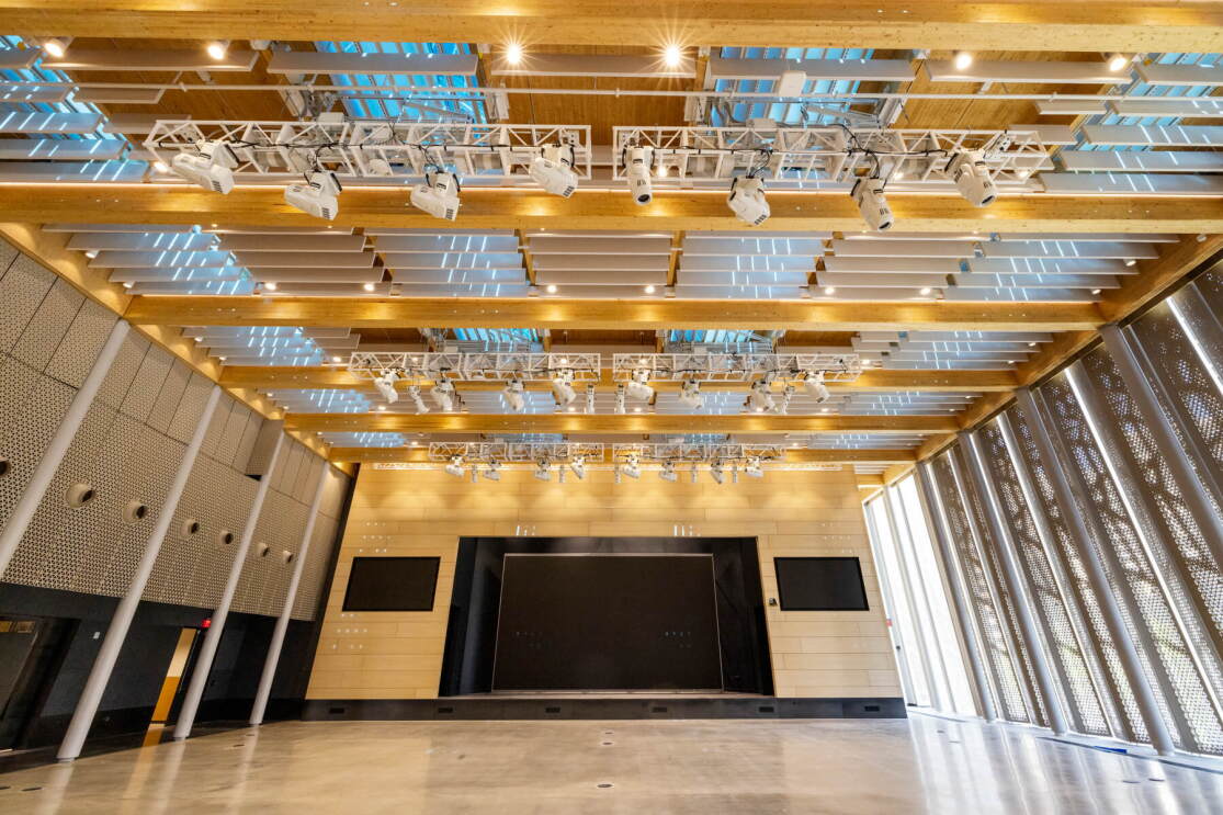 An image of the large public event space at Amazon's second headquarters. It's a large room with lots of lights and a big LED screen.