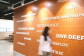Amazon's Leadership Principles featured on a wall in an Amazon office building. A woman is walking in front of them.