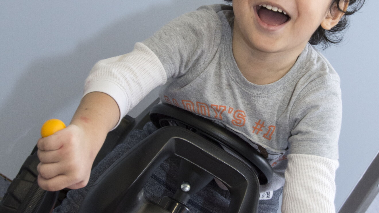 Ein ca. 3 Jahre alter Jungen auf einem Kinderbagger.