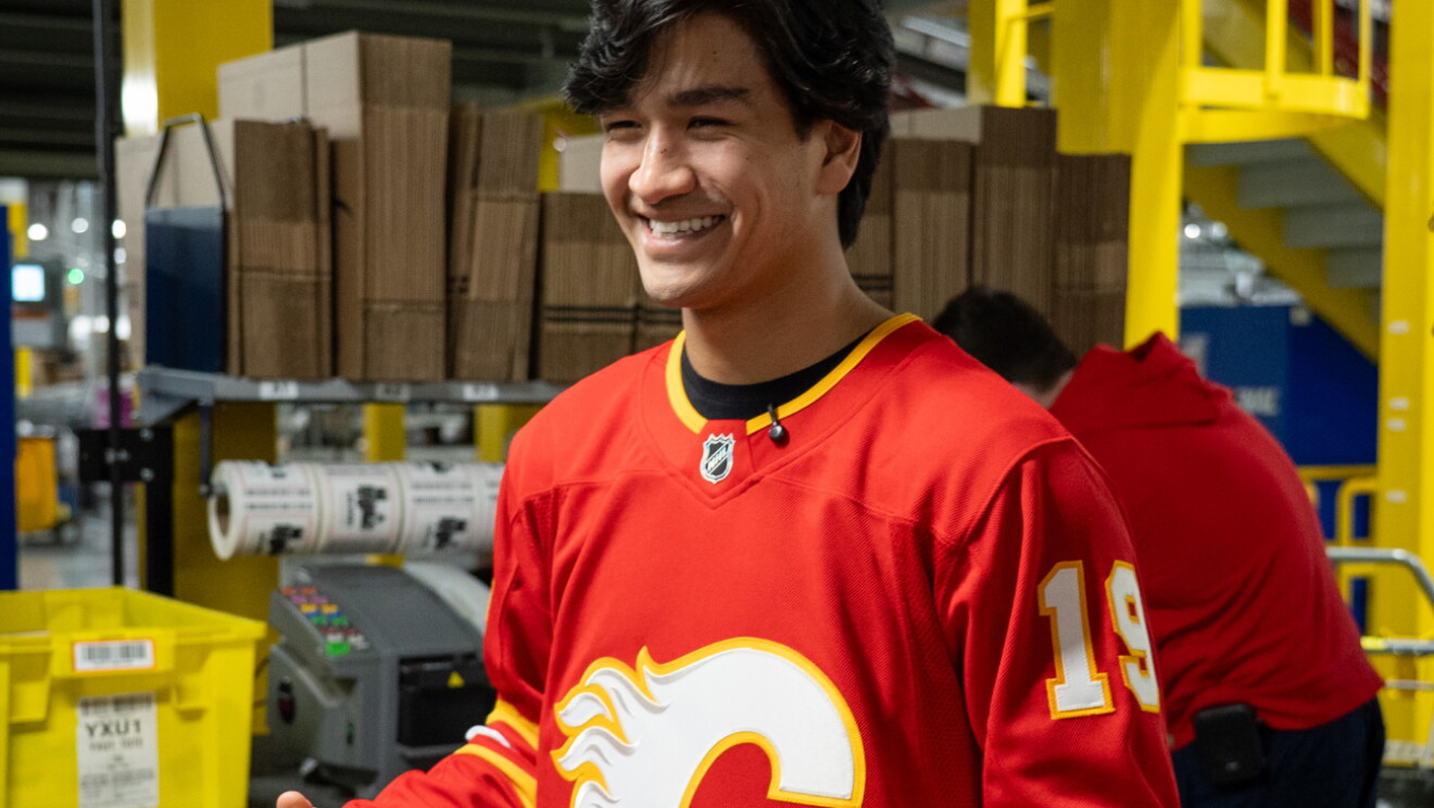 Two Calgary Flames hockey players packing and shipping Amazon boxes