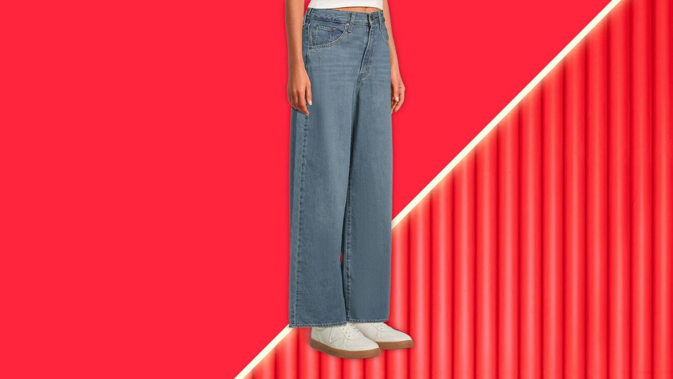 Wide-leg jeans on model against red background with diagonal line