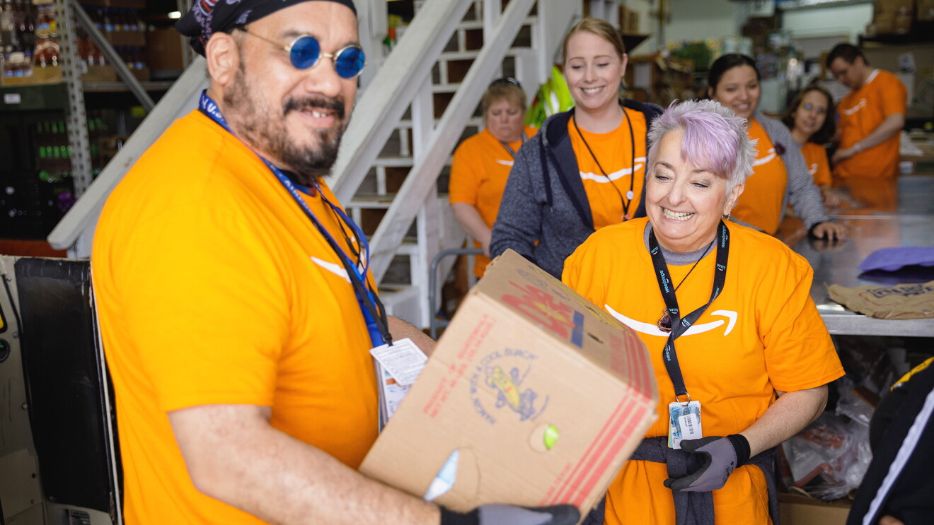 People volunteering in orange Amazon shirts.