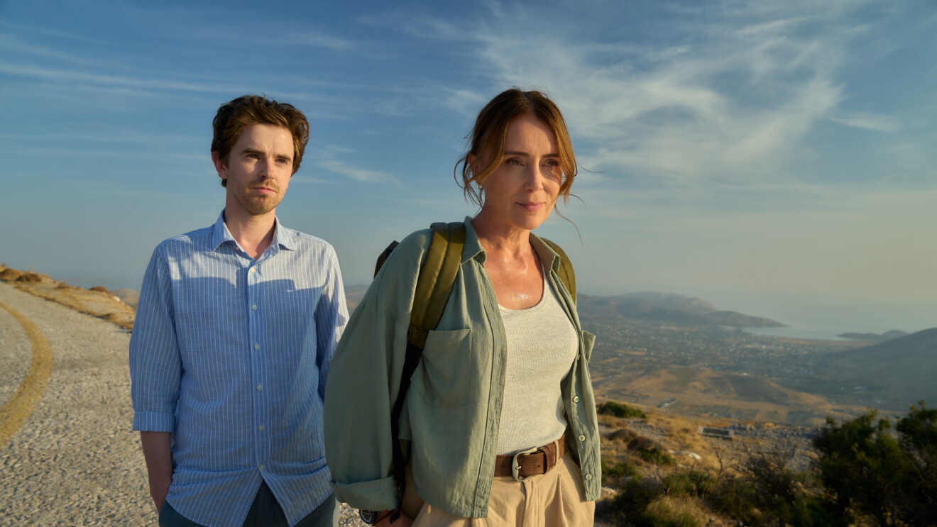 Two people, the lead characters of The Assassin, standing on a rocky path overlooking mountainous landscape