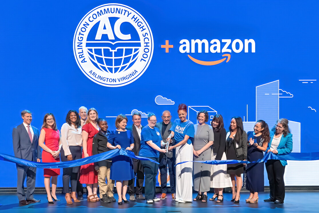 Ribbon cutting on stage with a group of people
