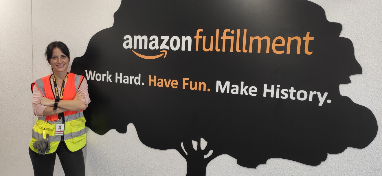 Salome in Sicherheitsweste vor einer Wand: Work hard, have fun, make history.
