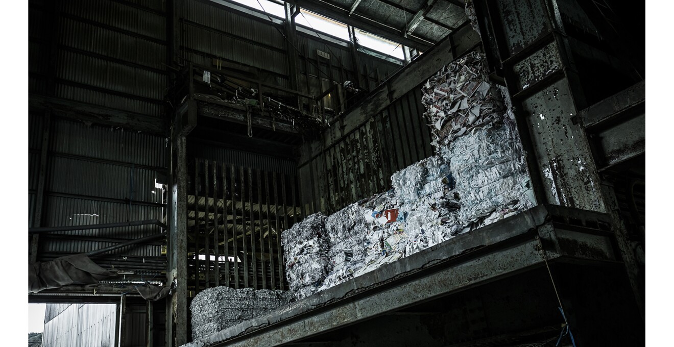 立方体に圧縮されて積まれている古紙