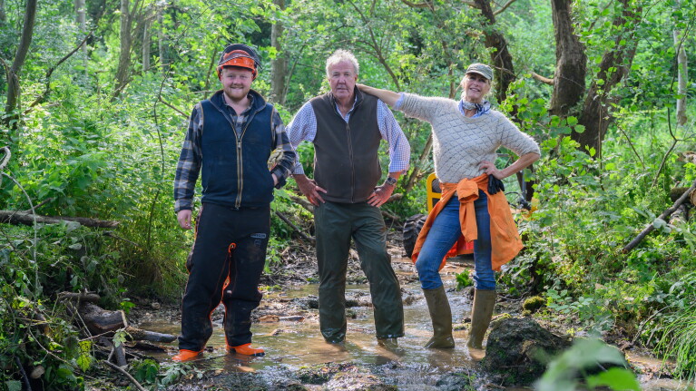 Kaleb Cooper, Jeremy Clarkson and Lisa Hogan stand together in a muddy puddle