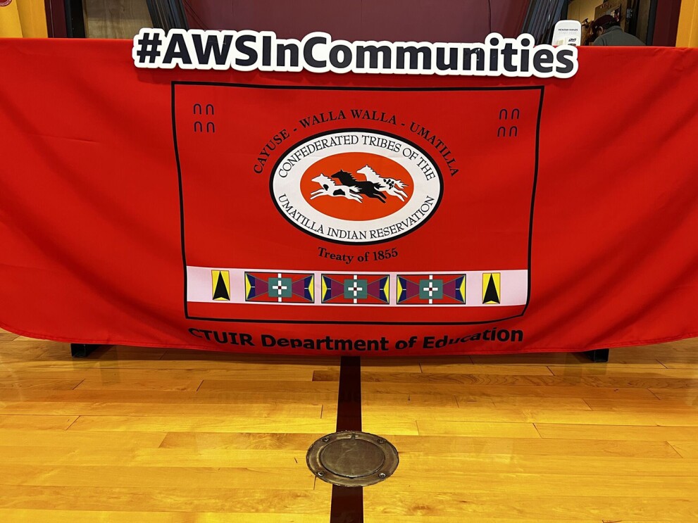 an image of a flag in a school gym. It stands for the Confederated Tribes of the Umatilla Indian Reservation.