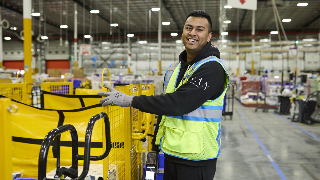 Amazon fulfilment centre team members smiling in high vis vests 