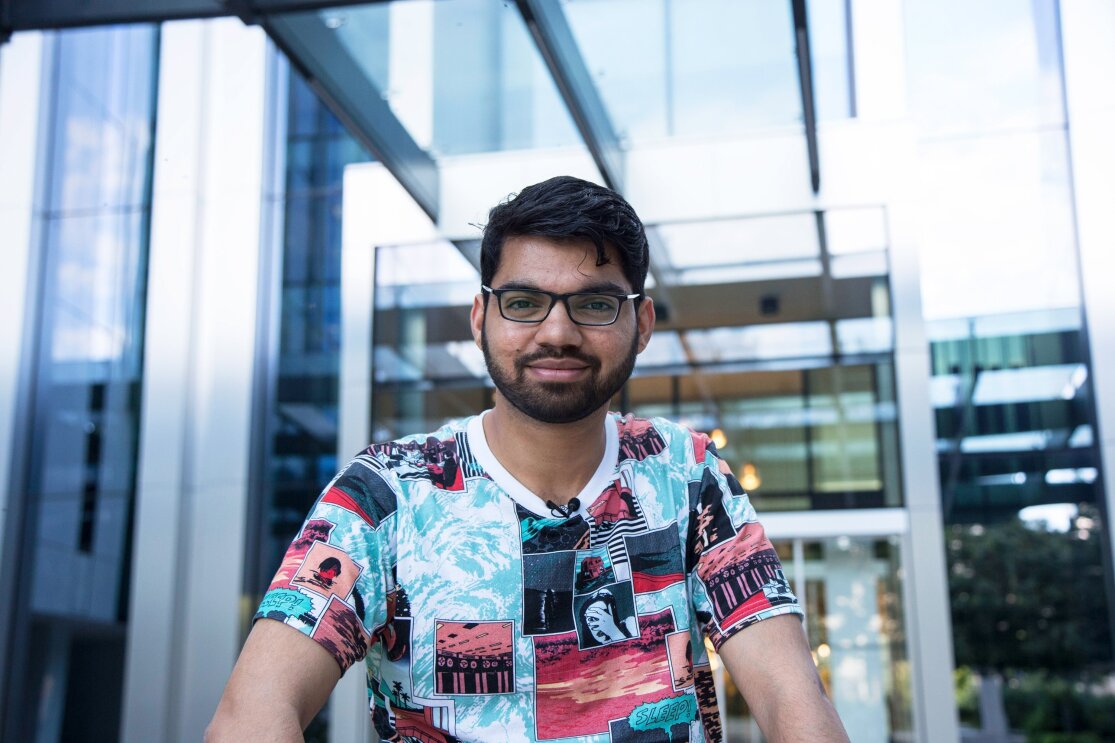 Siddhesh Krishnan, Learning & Development Associate ad Amazon, sorride in posa davanti all'ingresso degli uffici Corporate Amazon di Milano.