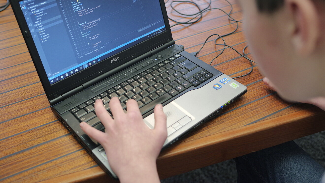 Junge tippt auf Laptop