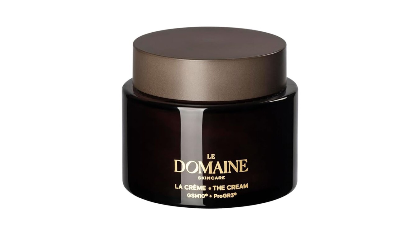 An image of a dark brown container with a light brown lid. The writing on the front of the container says Le Domaine in gold.