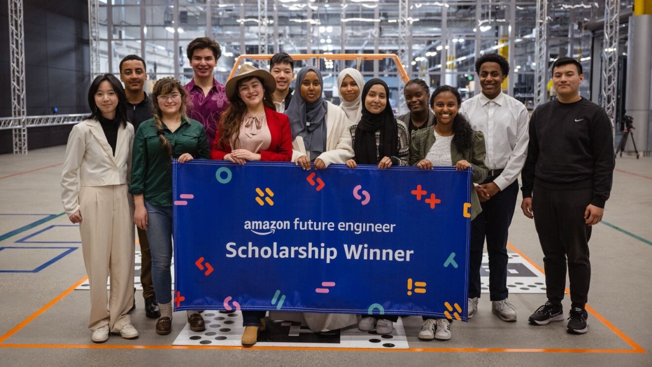 Amazon Future Engineer scholarship recipients standing in a group holding a blue banner