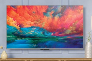 An image of a Fire TV mounted on a wall with the screen showing a painting of faded colors. 