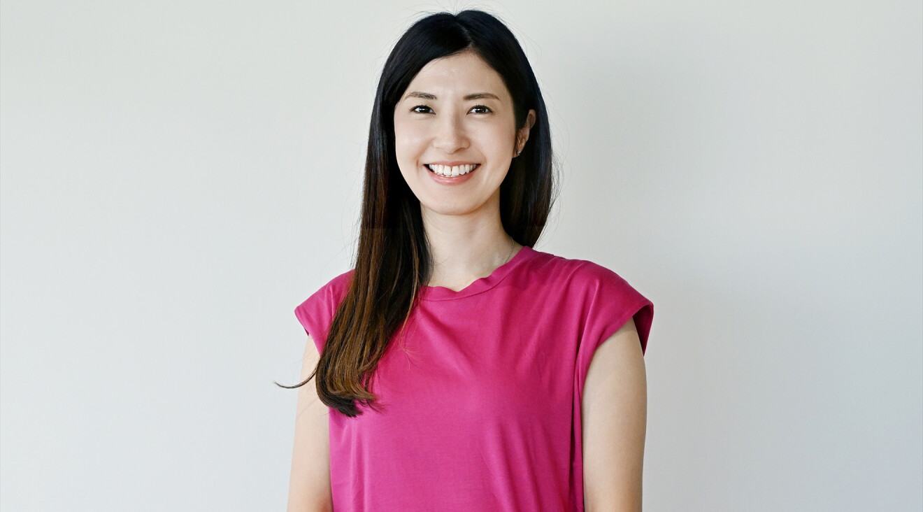 濃いピンク色のTシャツを着たロングヘアの女性