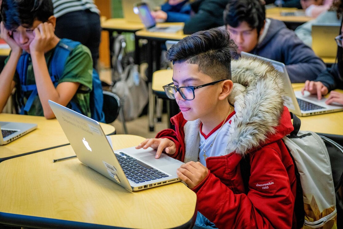 Students work on coding programs on laptop computers in a classroom at a New York City school. 