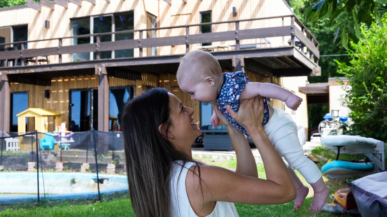 A woman holding her baby up in the air and smiling