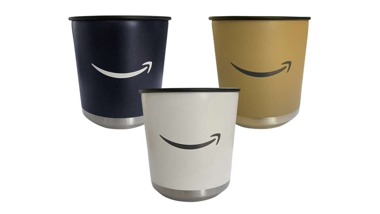 Amazonロゴが印刷された黒、白、ブラウンのカップ3個が並んで置かれている