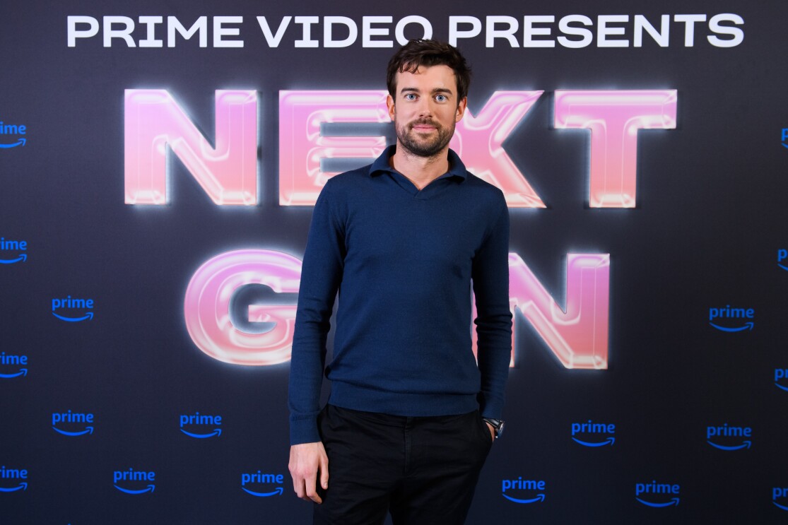 A tall man standing in front of a prime video branded backdrop