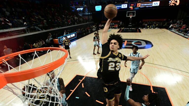 High-flying slam dunk attempt during basketball game.