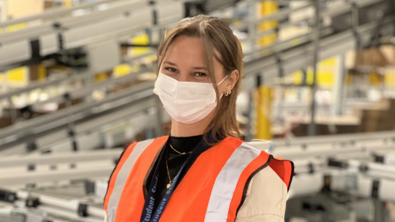 Azubi Leandra Stengel mit Maske und Tablet während ihrer Ausbildung bei Amazon