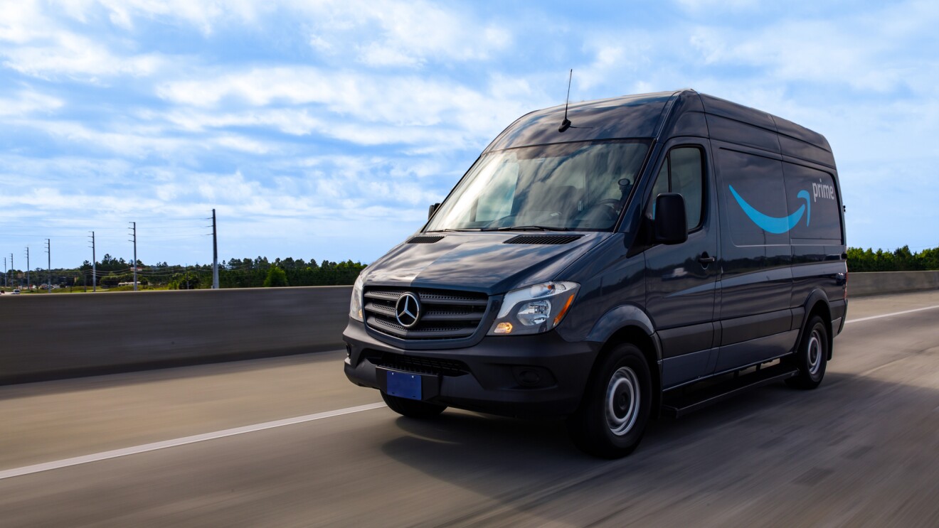 A cargo van decorated with the Amazon smile logo and the word "Prime."