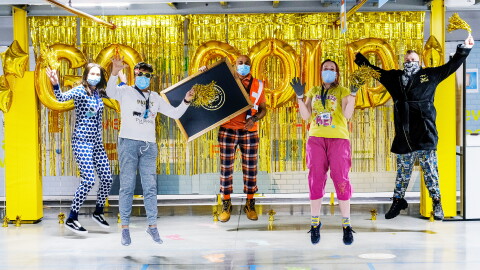 Amazon Goes Gold staff in front of gold 'go gold' banner