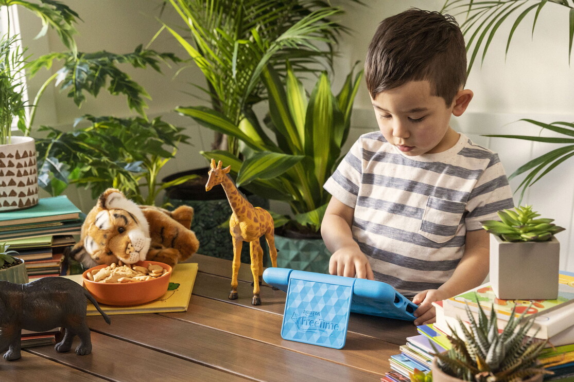 A child plays on a Fire tablet in a living room 