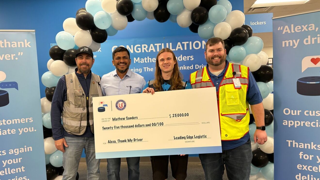 'Alexa, thank my driver' winners hold their winnings in a big check while they stand next to colleagues.