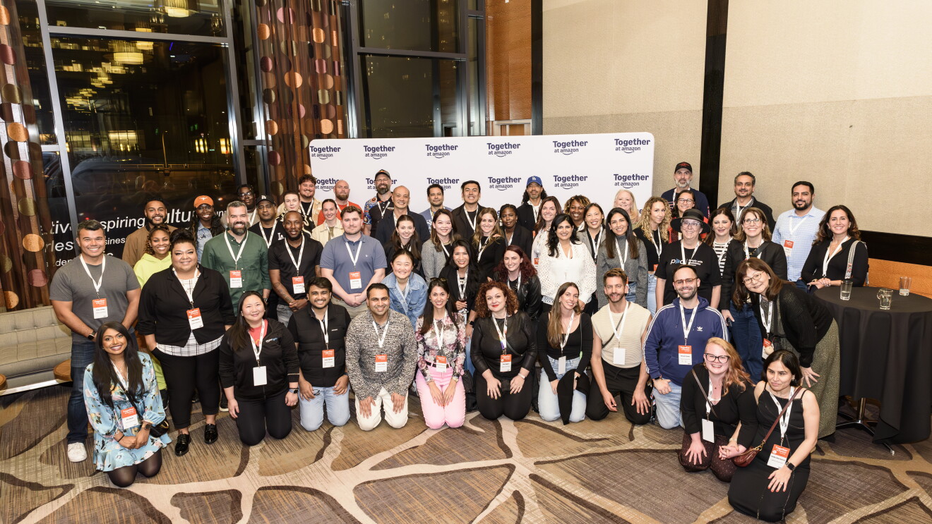 Large diverse group posing at 'Together at Amazon' event