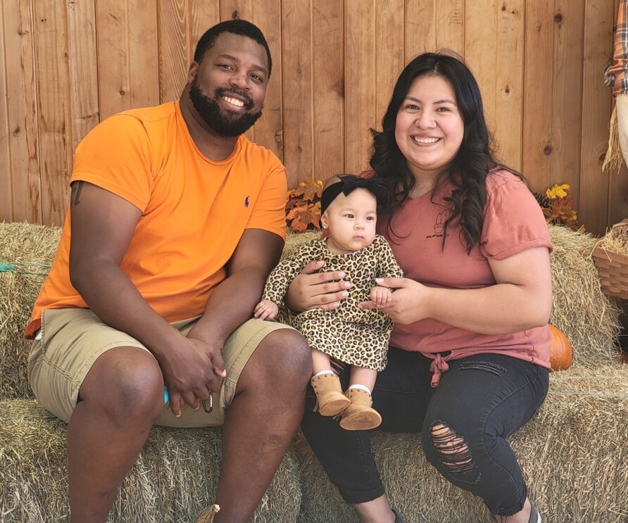 A woman who works at Amazon, poses with her family. 