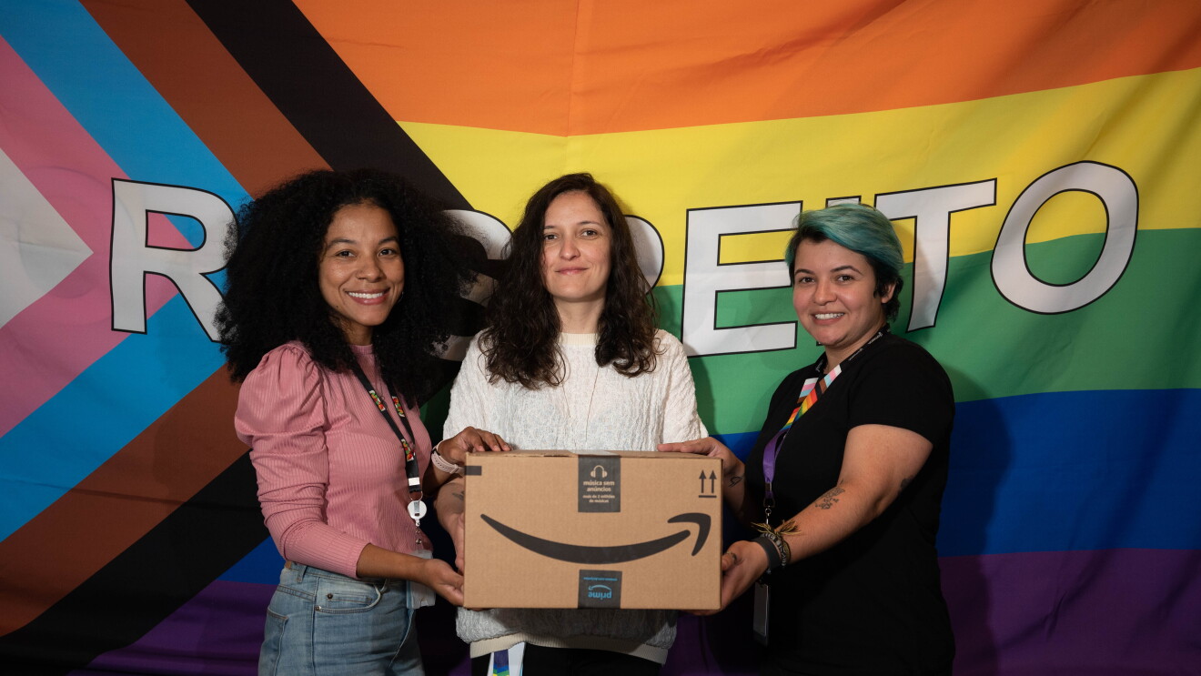 Mulheres seguram caixa da Amazon no Pride