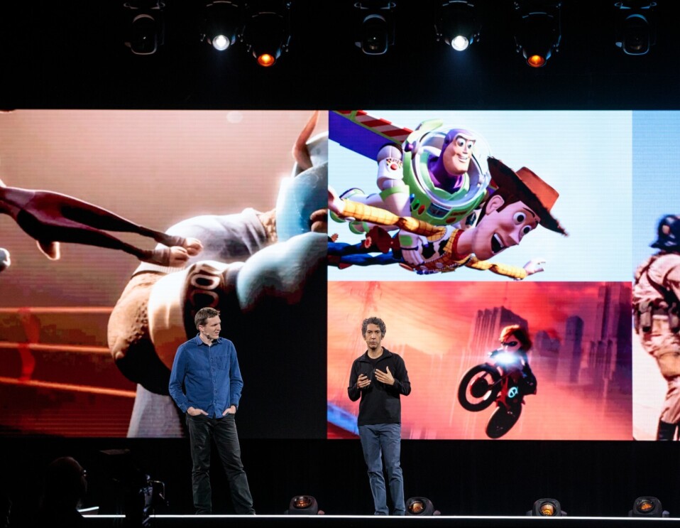 Two men, Morgan Pope and Tony Dohi stand on stage at Amazon re:MARS, in front of a screen showing Disney characters in motion.