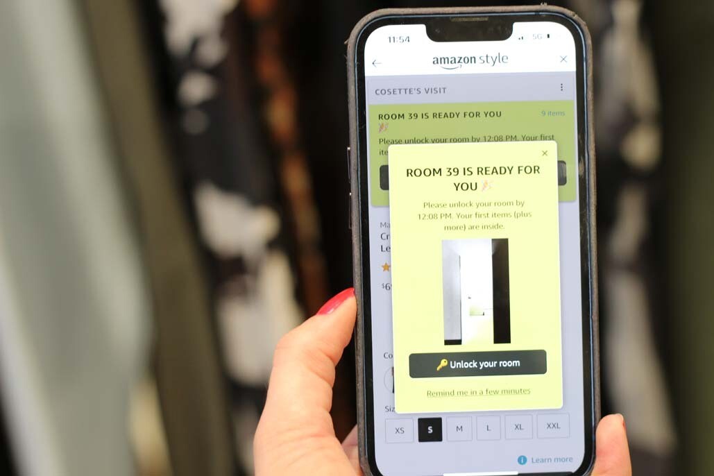 An image of a hand holding a phone. On the screen you can see a pop up that says the room is ready.