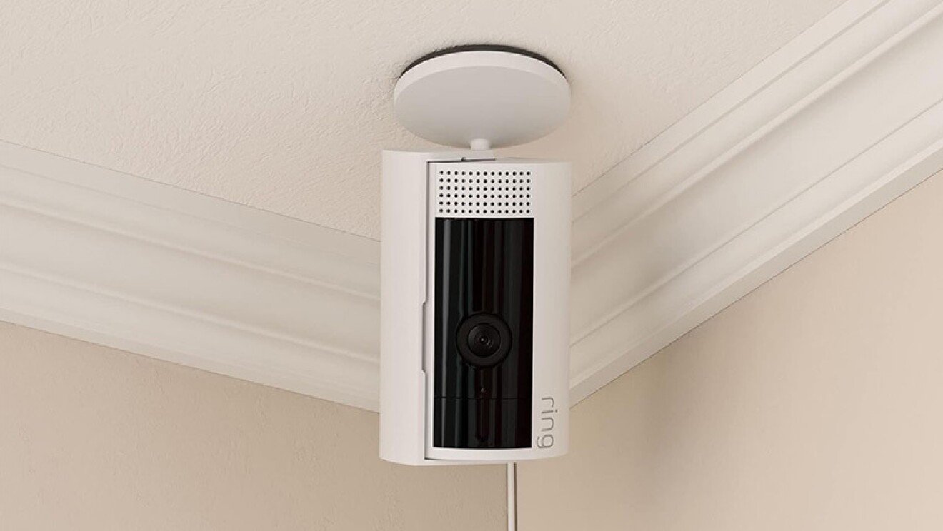 天井からぶら下がっている白い円筒形のセキュリティカメラ。Amazon Ring