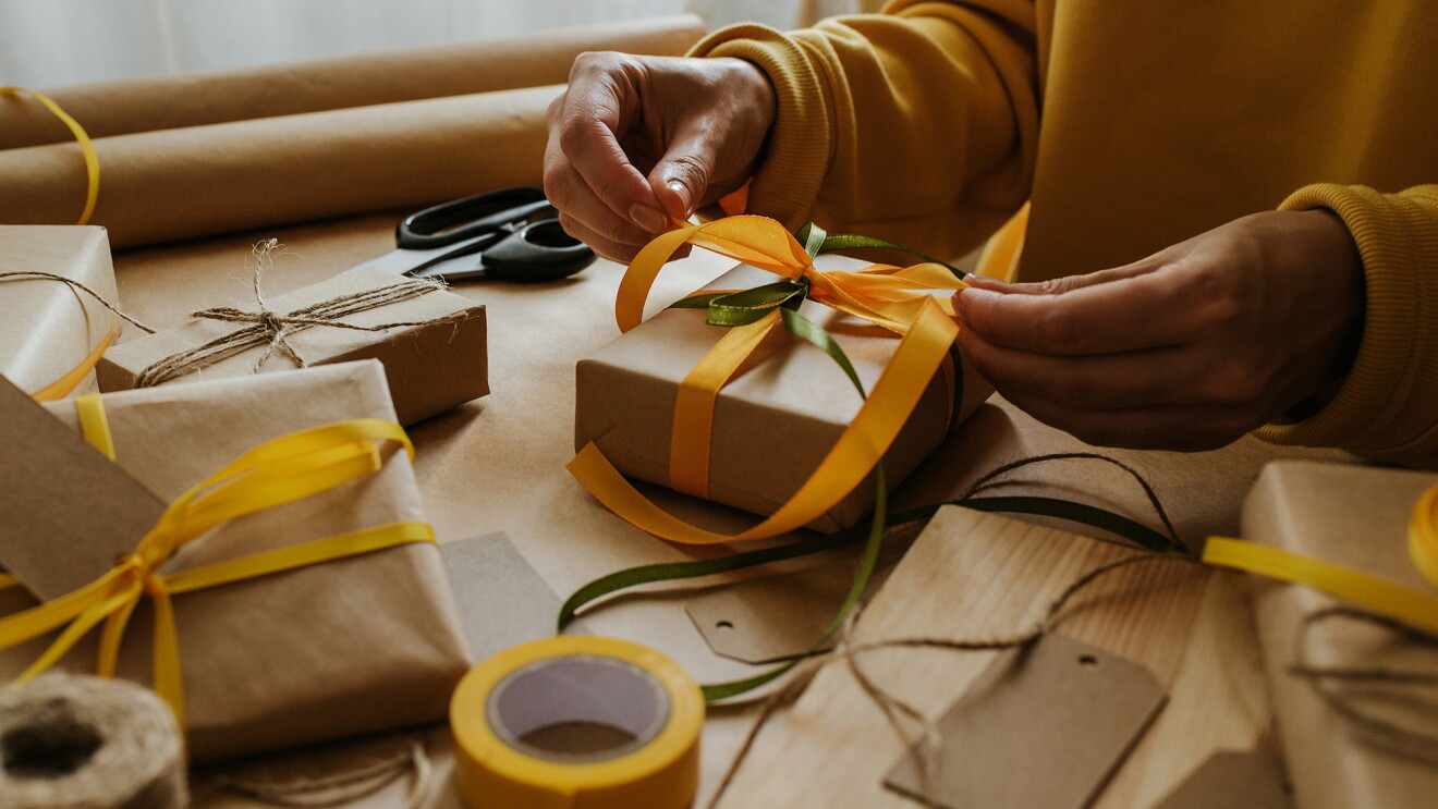 An image of a woman's hands wrapping gifts.
