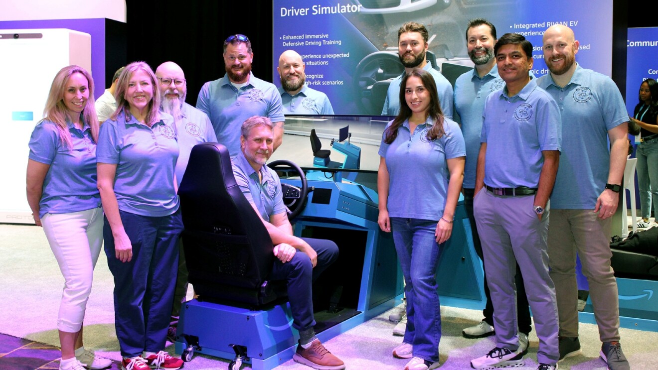 Team posing with driver simulator at technology showcase event