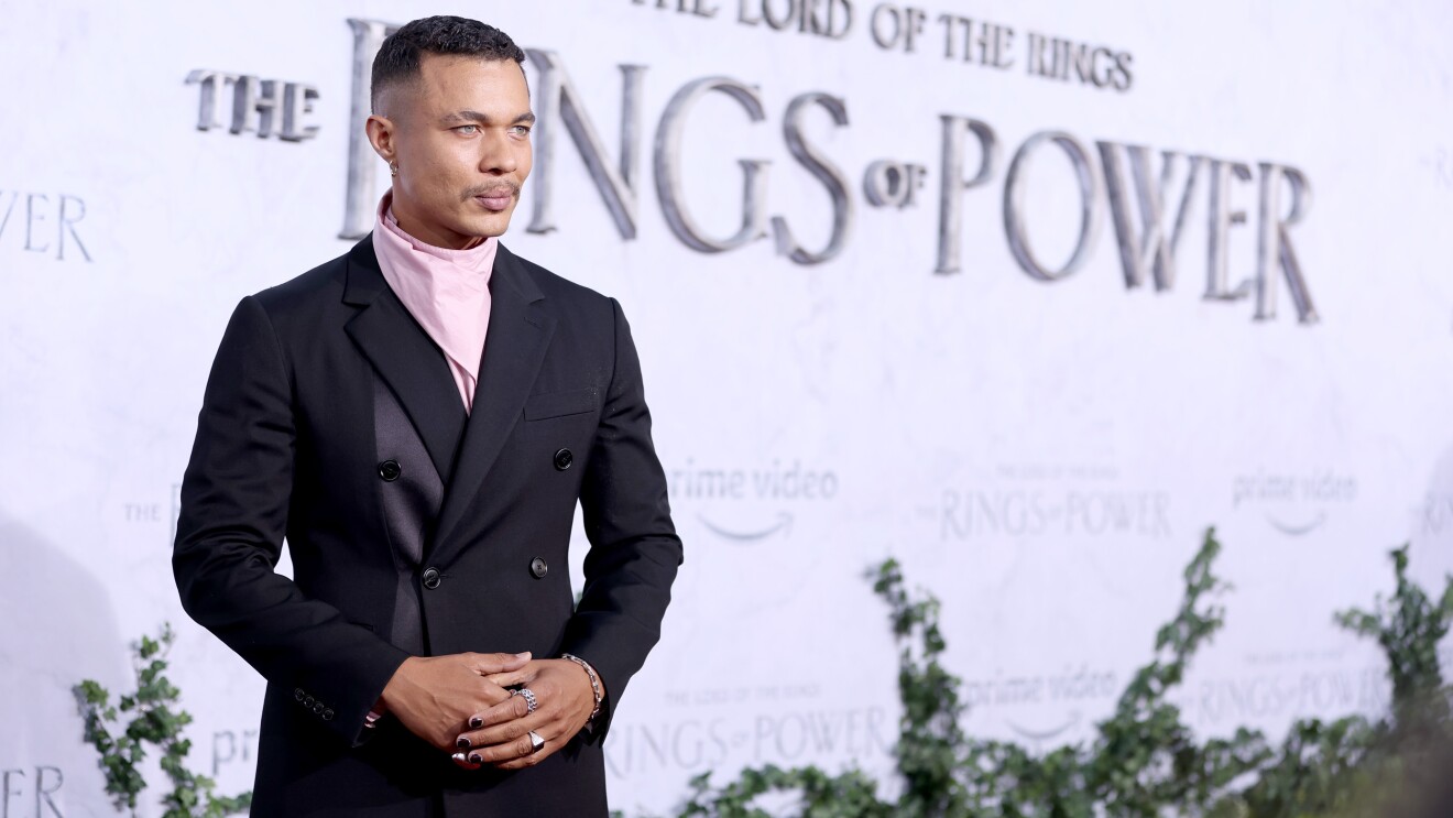 A man smiles for a photo on the red carpet of the Lord of the Rings the Rings of Power premiere