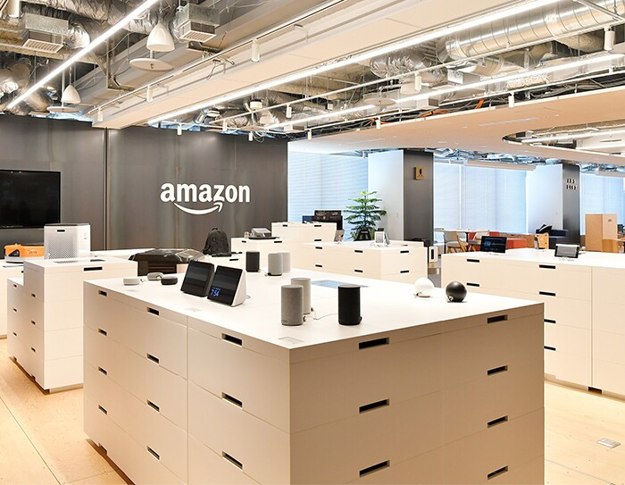 台の上に置かれたさまざまな製品の奥にAmazonのロゴが見える