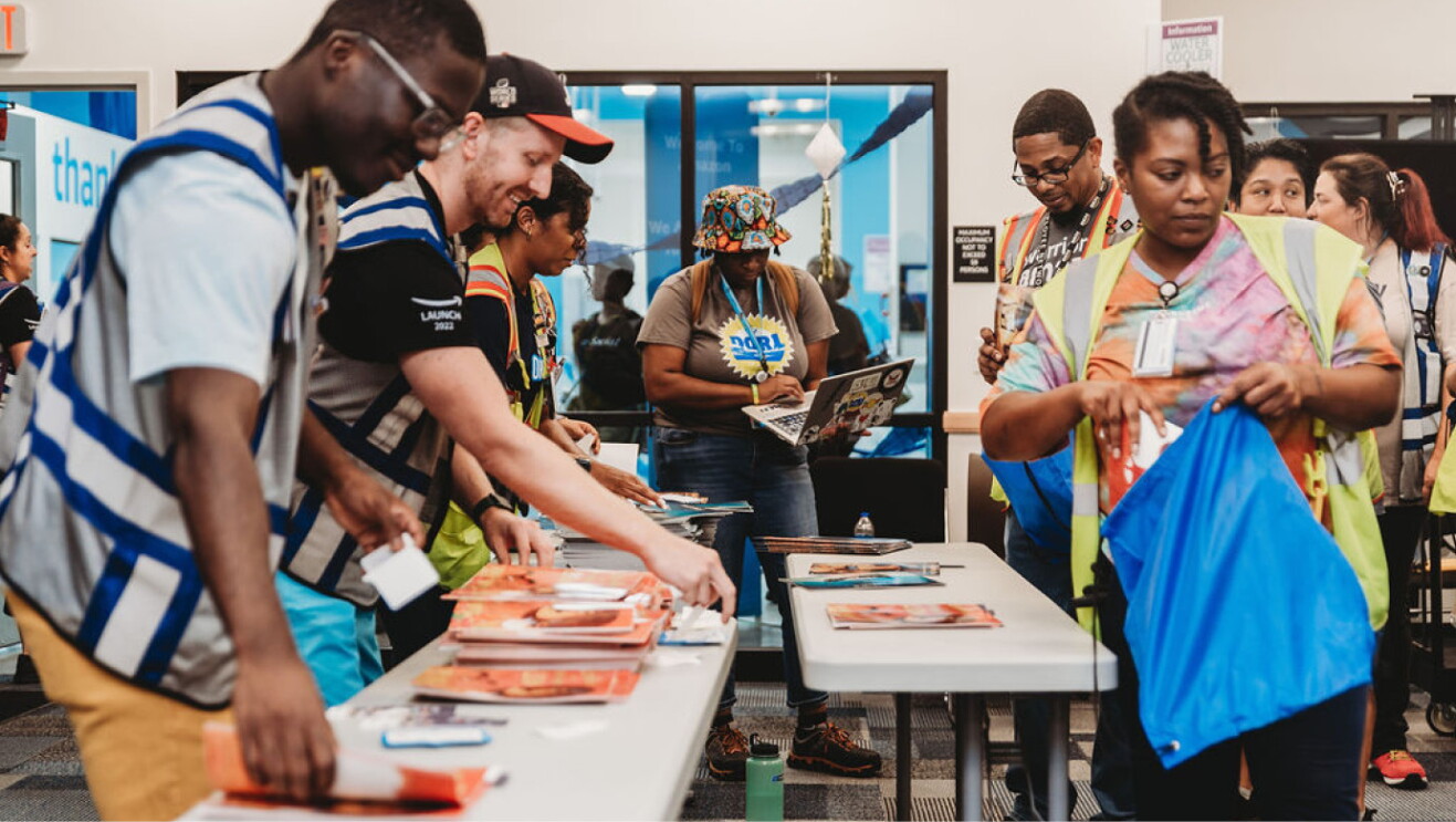 An image of people volunteering giving away books.