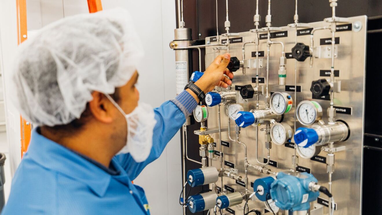 An employee adjusting equipment at Project Kuiper facility