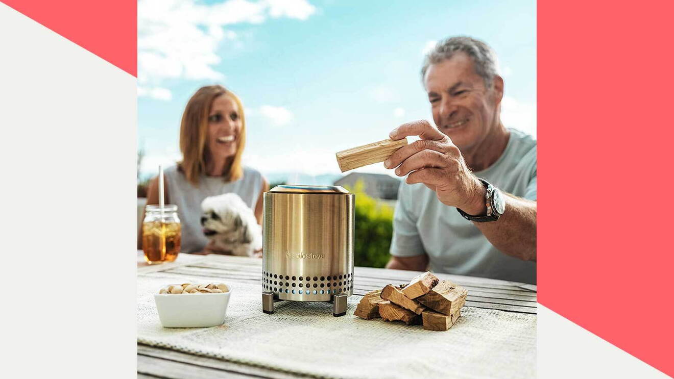 Prime day 2023 live blog best deals: man sitting at a table while adding a piece of wood to the solo stove mesa portable fire pit