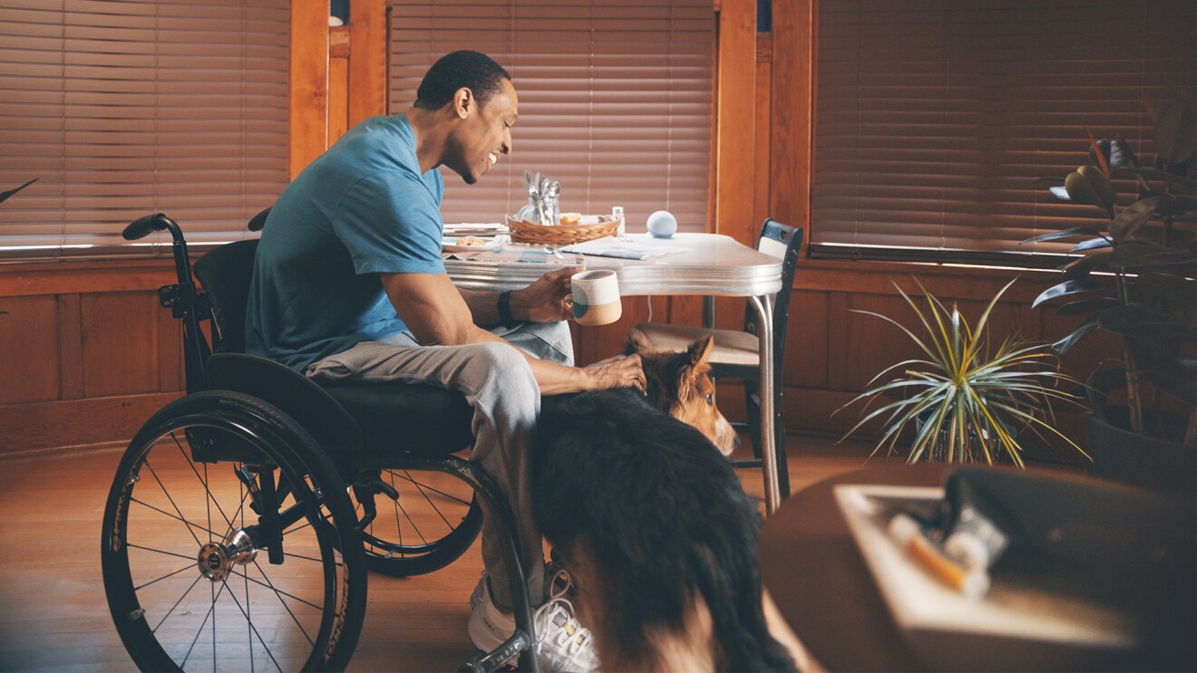 一个男人坐在轮椅上的形象与他的狗