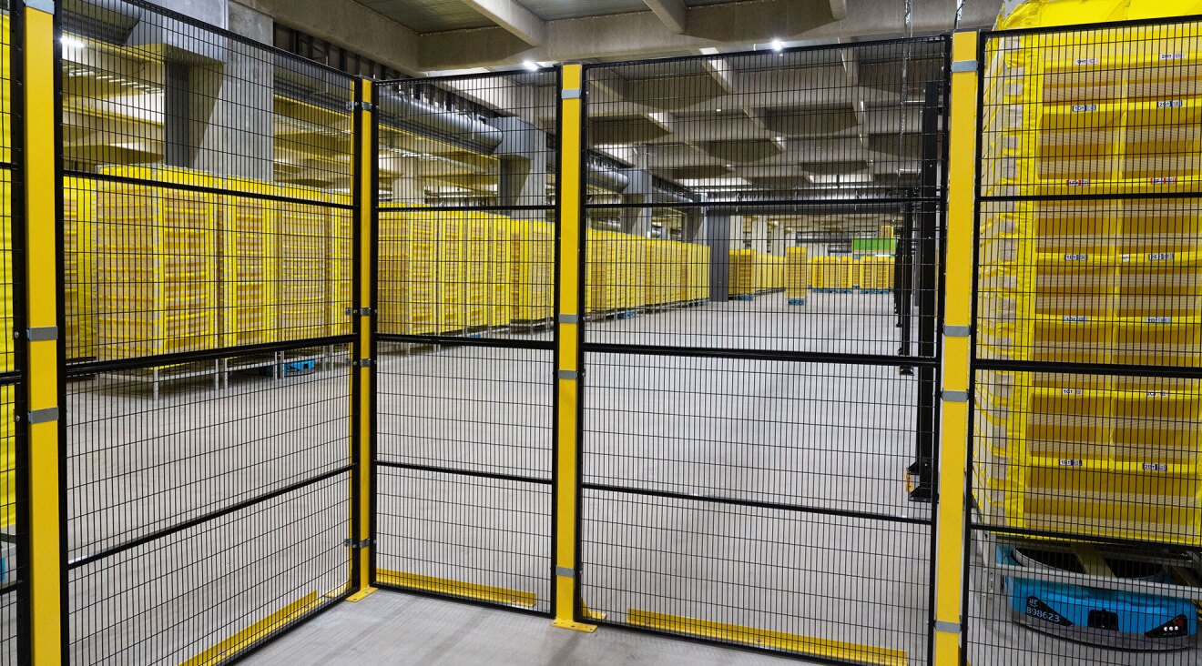 黄色い棚の手前に黒い網がついた塀が立てられている