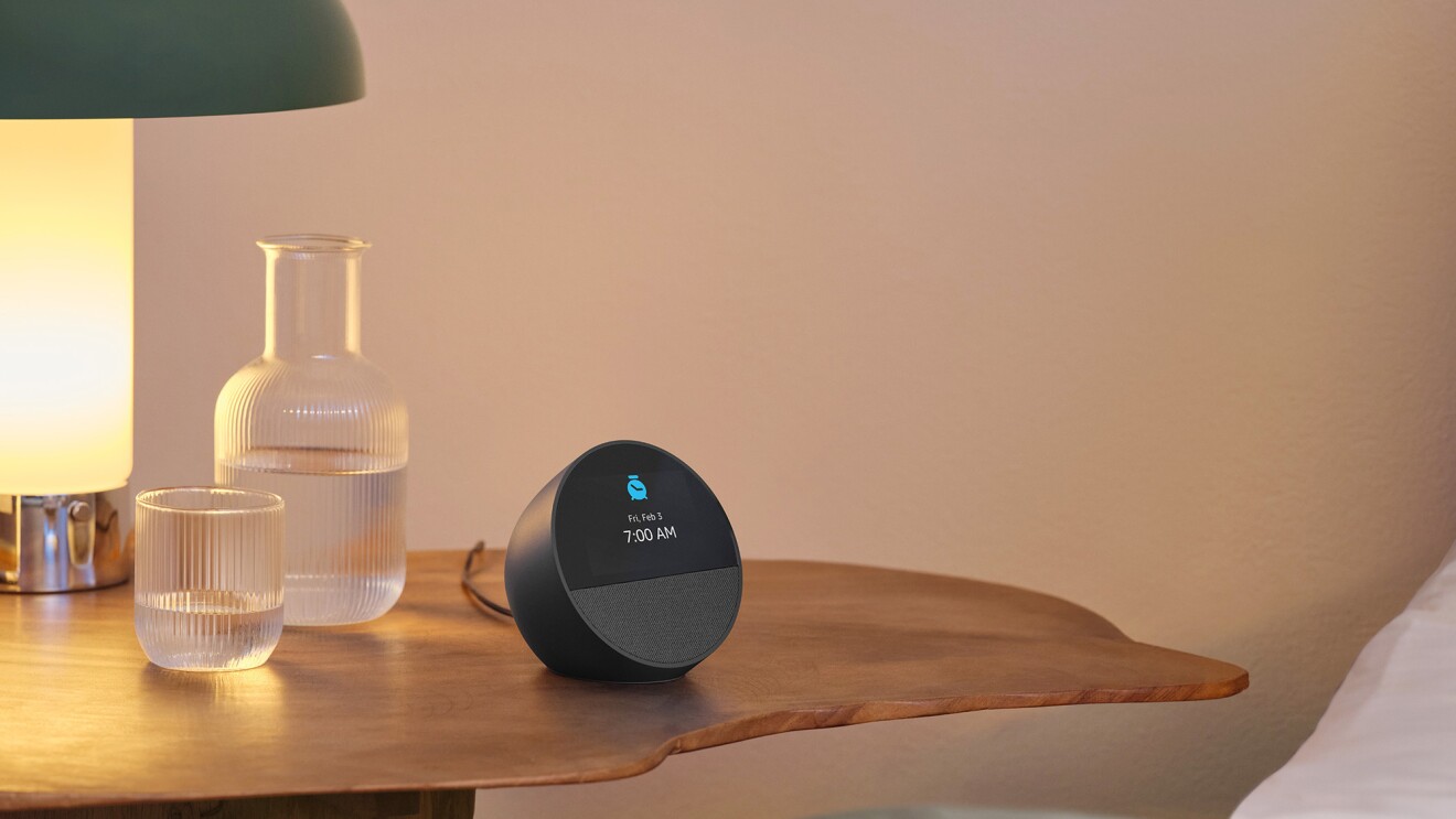 Echo Spot on wooden nightstand with lamp and glass carafe