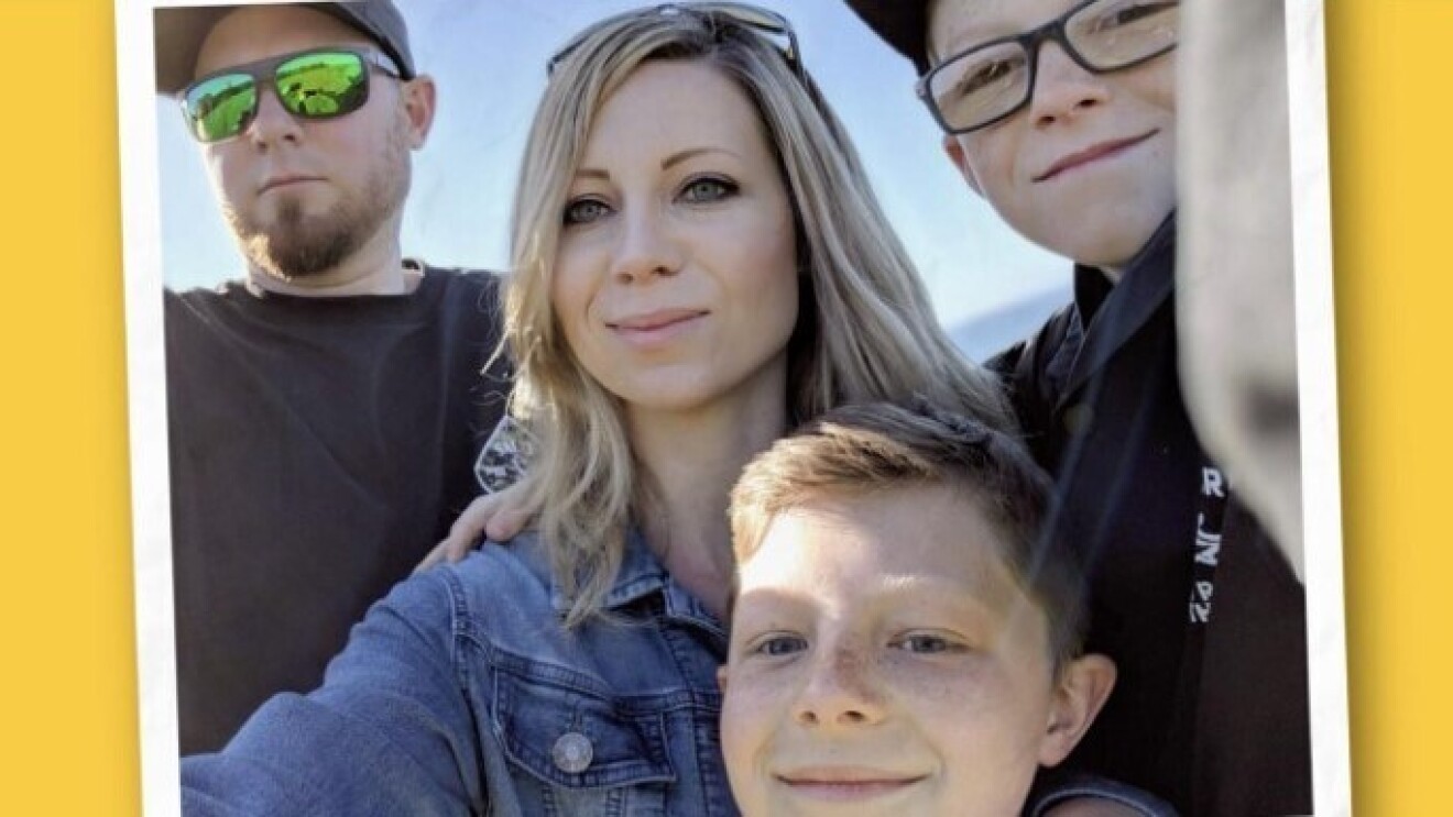 Courtney takes a selfie outside with her husband and two sons.