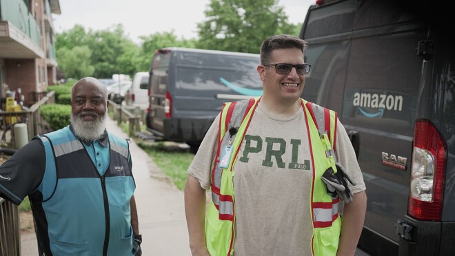 志愿者和亚马逊员工将必备家具和家居用品装上亚马逊的送货货车。