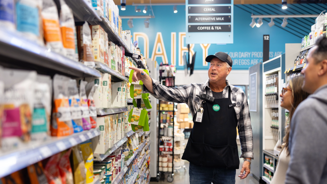 whole foods employee in front of groceries
