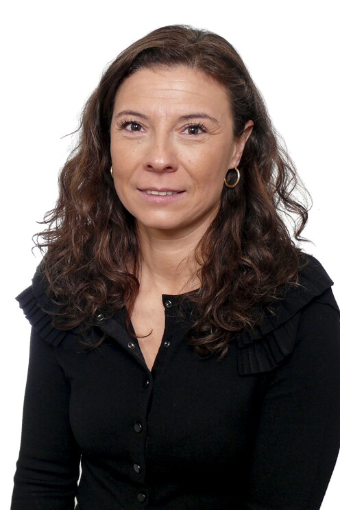 Carmen María Martínez Martínez-Burbana, responsable de Relaciones Laborales. Mirando a cámara con el pelo largo, castaño y ondulado. Con pendientes, sonriente y camisa gris. LLeva un jersy de punto negro con volantes en los hombros.